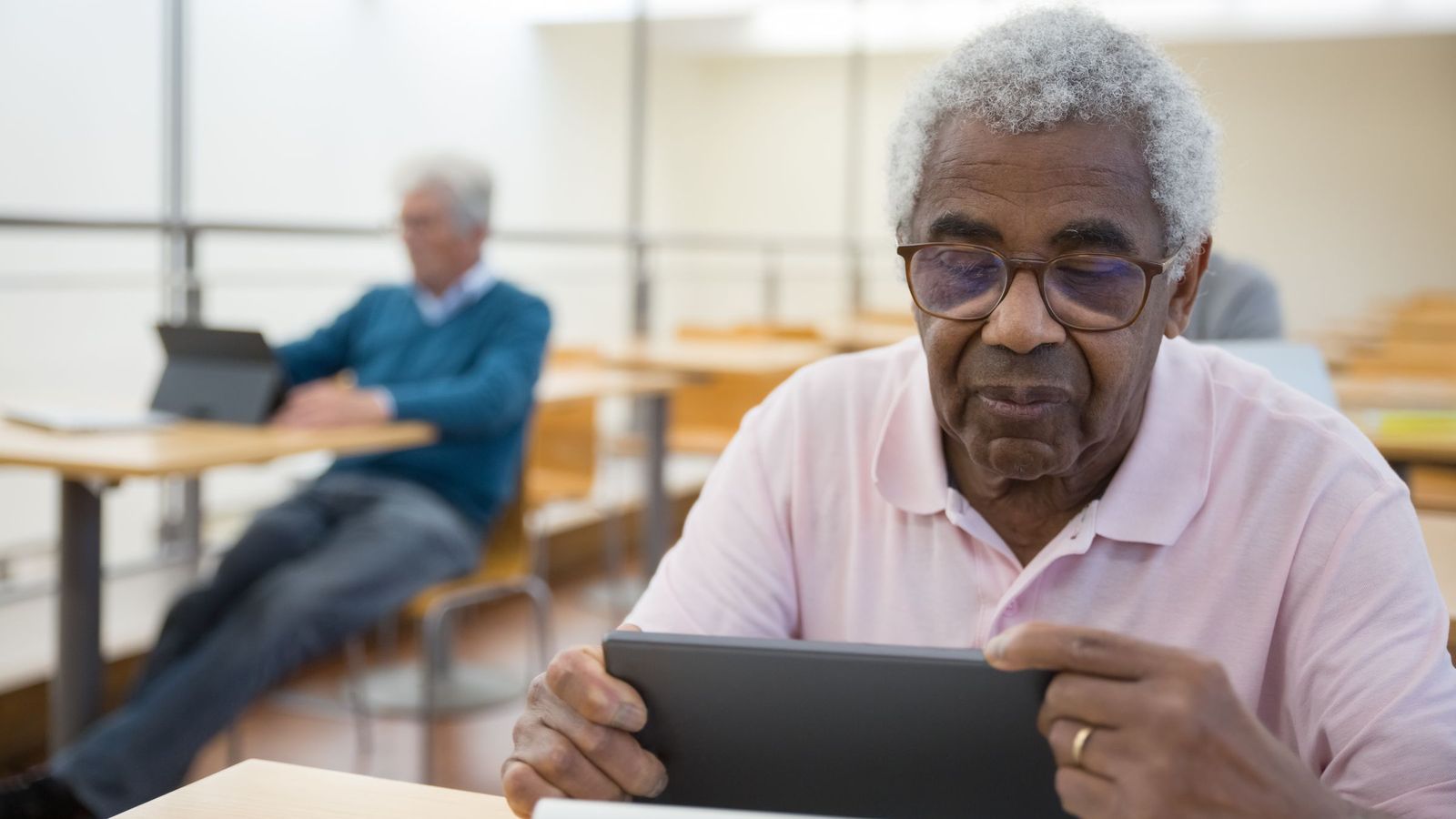 An older man using a tablet at a table